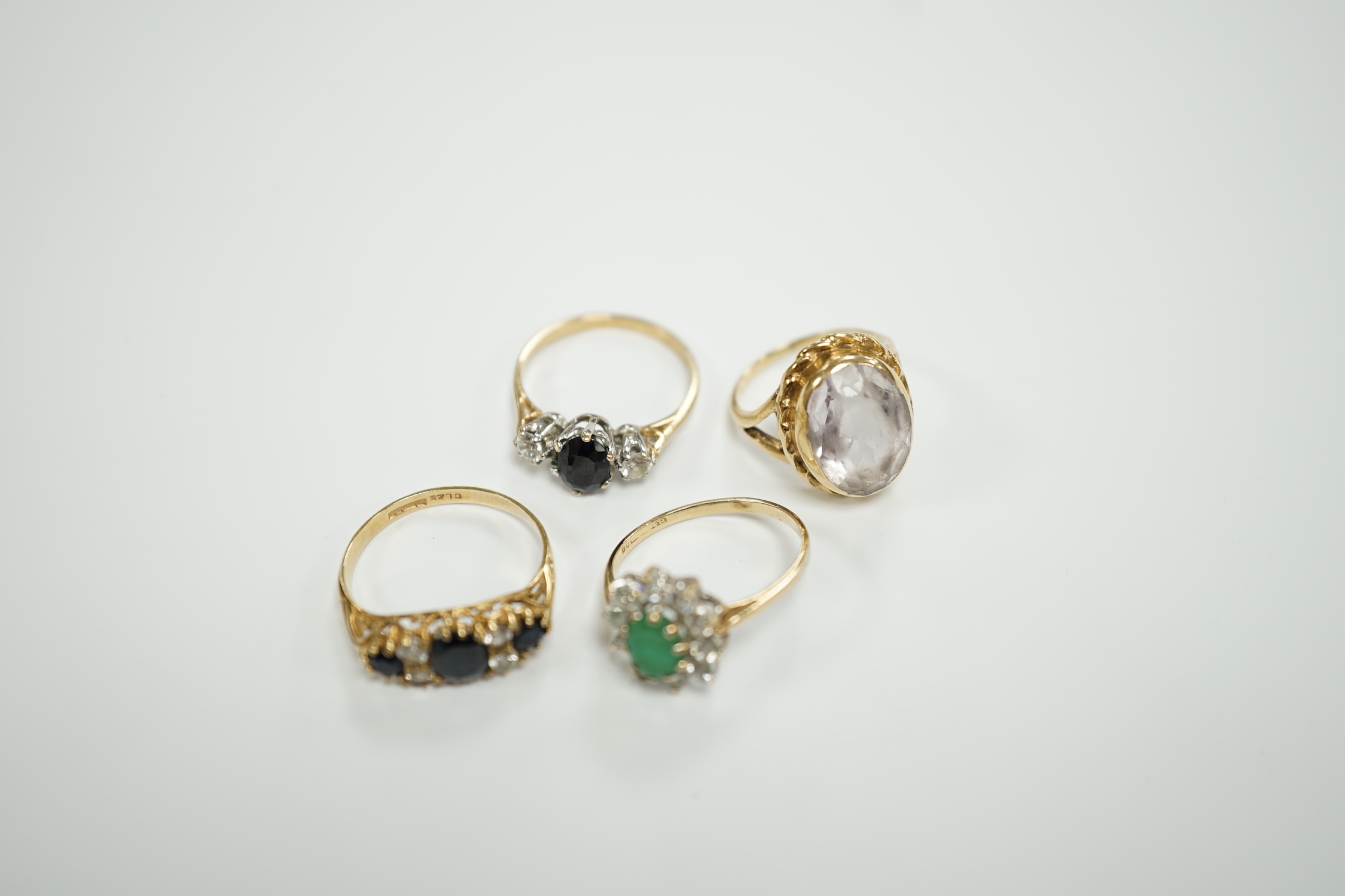Four assorted modern 9ct gold and gem set dress rings, including sapphire and simulated diamond, gross weight 9.9 grams.